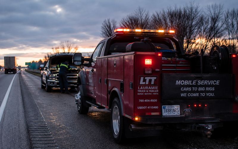 LTT mobile service truck helping a broken-down pickup on the highway shoulder